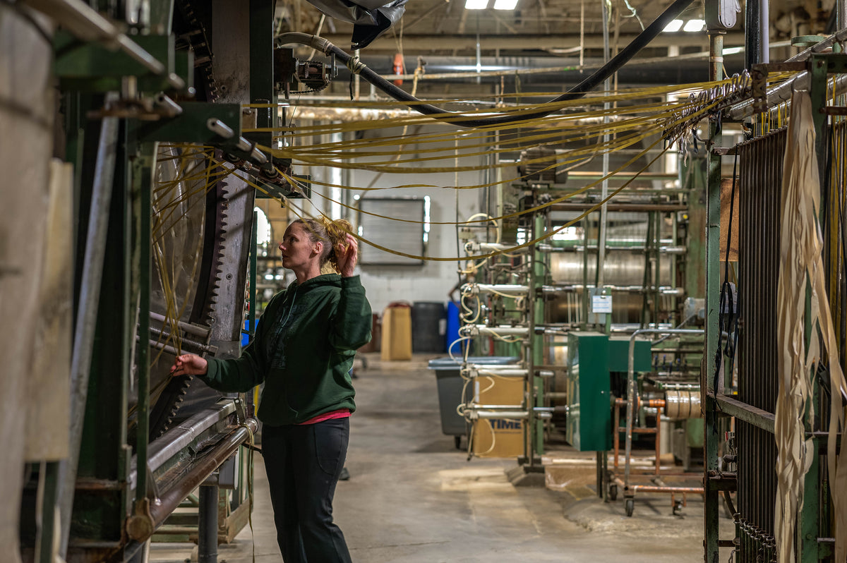 Ribbon Factory team member tending weaving equipment on the mill floor