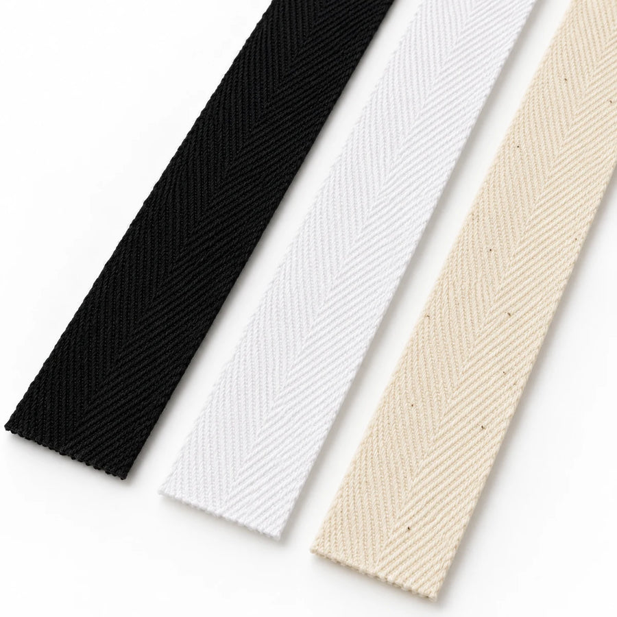 Straight black, white and natural cotton twill tapes showing the woven texture